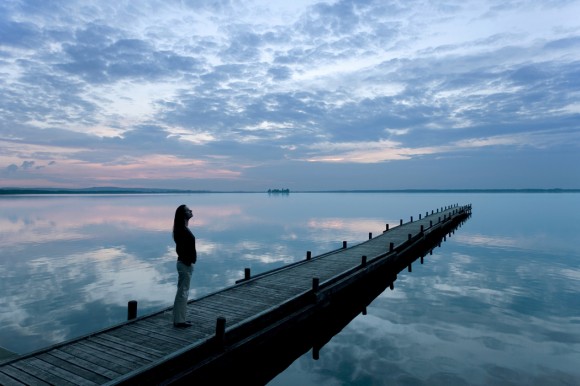 Woman on dock at lake (iStockphoto)