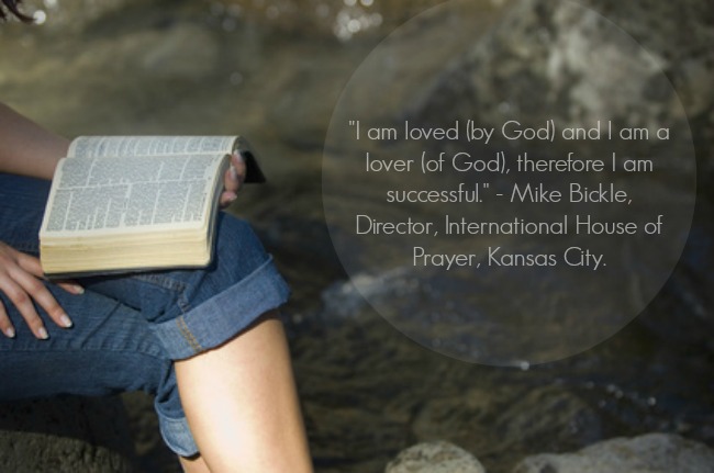 Young woman reading bible by river in summer