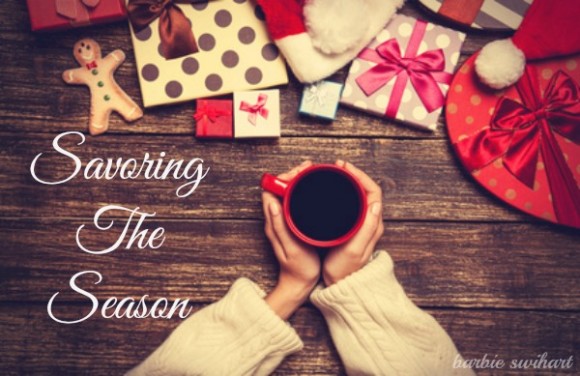 Female holding cup of coffee on wooden table near christmas gifts